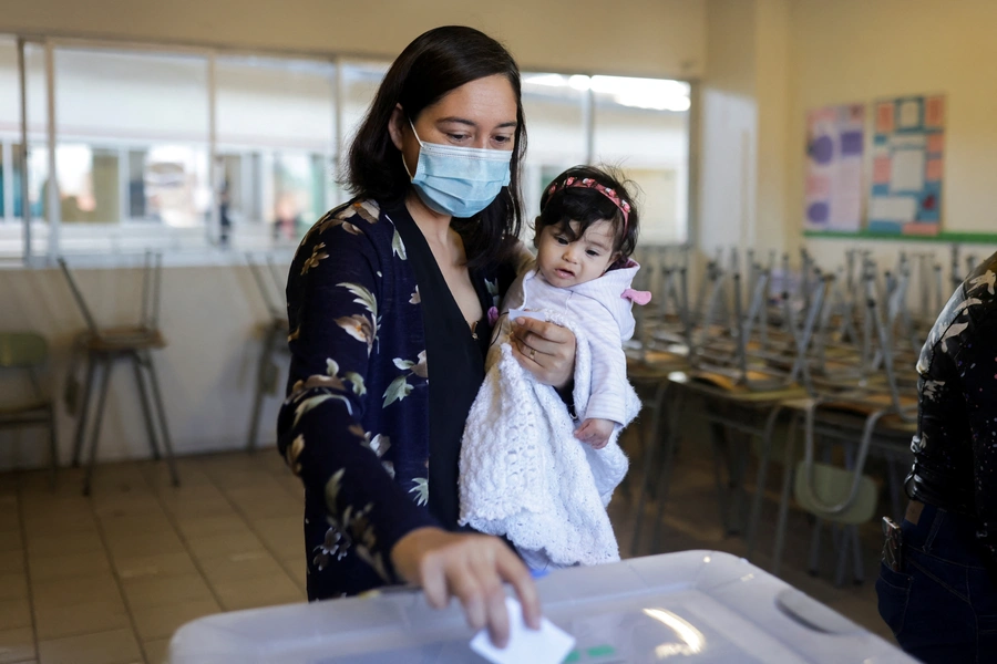 A woman holding a baby in Santiago, Chile, September 4, 2022.